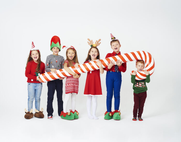 Happy children holding huge candy cane