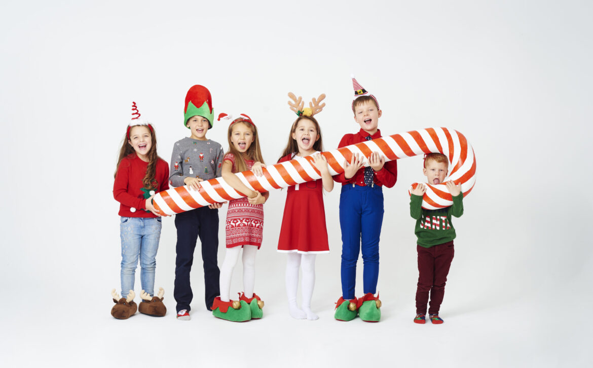 Happy children holding huge candy cane